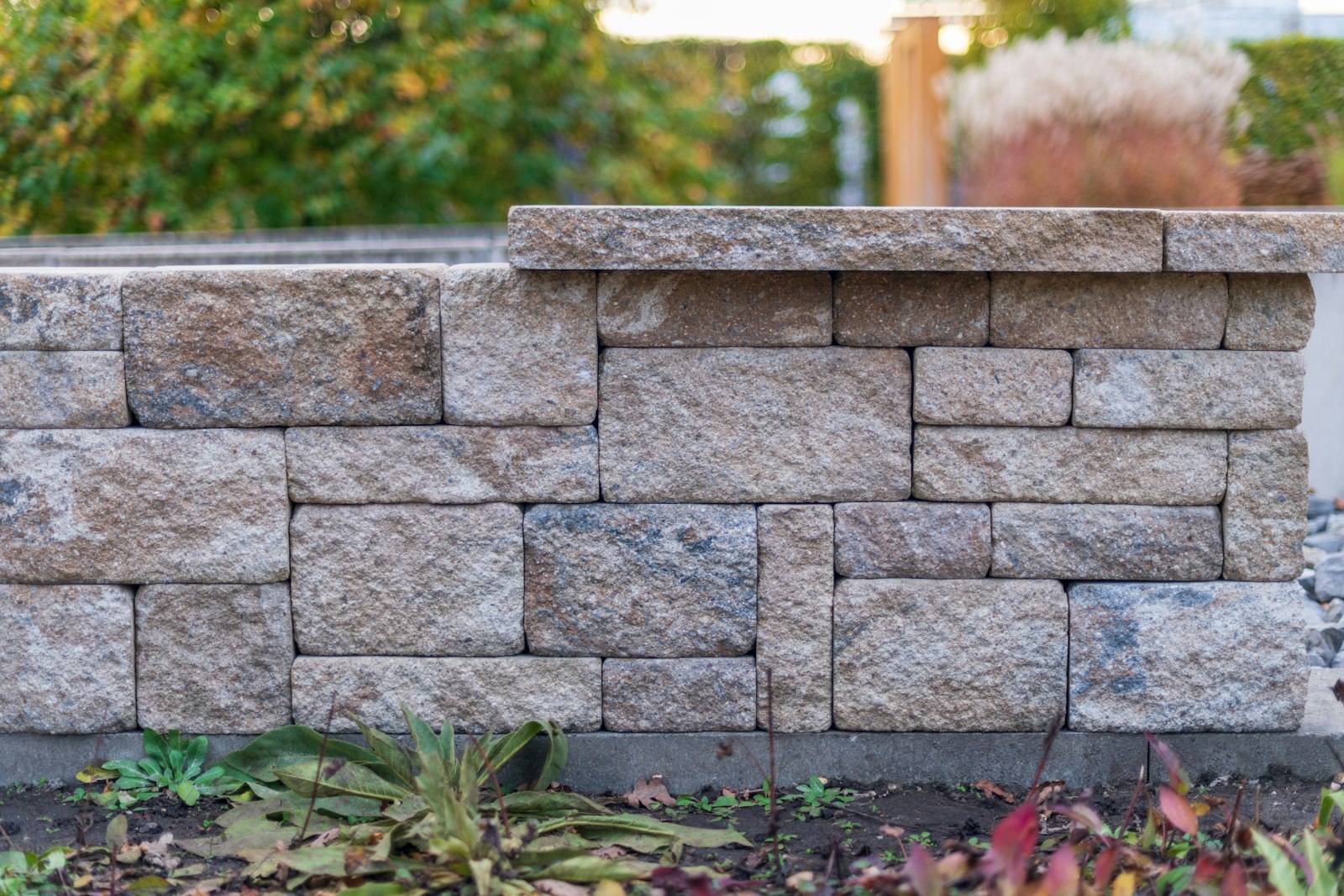 Dry-stacked stone retaining wall with a planting bed at its base